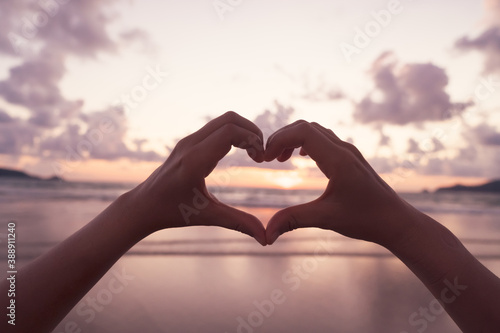 Woman hand do heart shape on blue sky  and bokeh background.