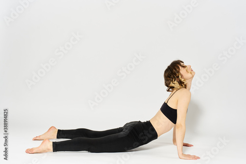 Sportive woman will do the exercise lying on the floor Gymnastics fitness in a bright room