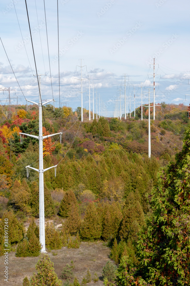 A group of electrical power lines crosses the Rouge River Valley in an urban park in Toronto (Scarborough), Ontario in the midst of the Autumn foliage. A group of electrical power lines crosses the Rouge River Valley in an urban park in Toronto (Scarborough), Ontario in the midst of the Autumn foliage.