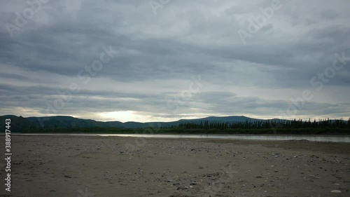 River valley with wide sandy shore and distant mountains, extreme wide shot, panshot photo