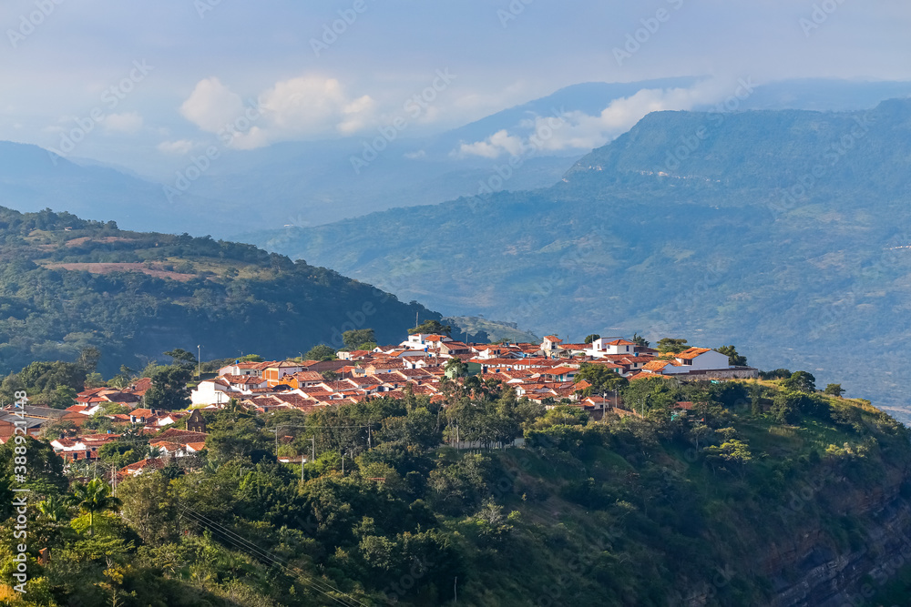 Aerial view of the historic town Barichara high on a cliff  in sunlight, mountains in background, Colombia 