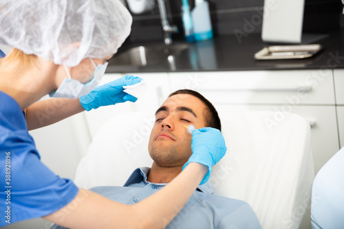 Portrait of male patient during cosmetology procedure in beauty clinic, getting carbon dioxide injections for face skin rejuvenation