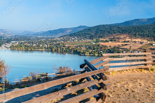 Tableau sur toile view from behind a wooden, log fence of the lake and hills covered with green tr