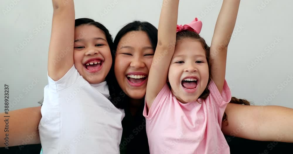 Happy mother and children celebrating success raising arms in air Happy mother and children celebrating success raising arms in air