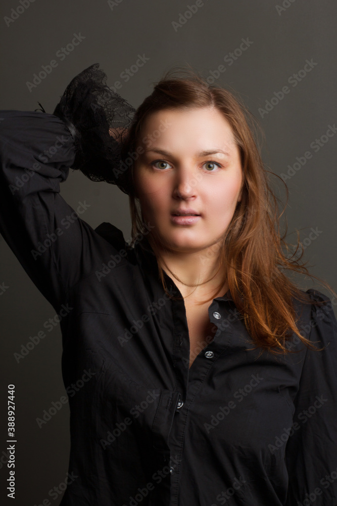 Portrait of a young brunette woman, in dark colors, in the Studio.