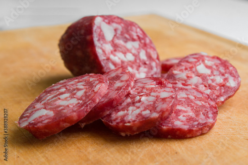 Sliced Appetizing dry smoked sausage on wooden background