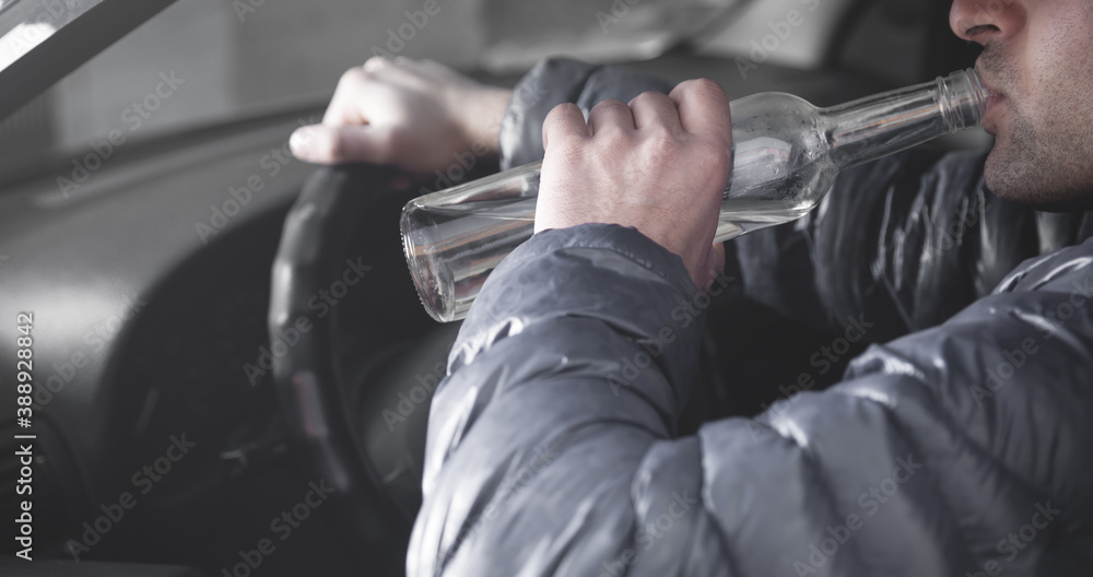 Man drinking alcohol while driving the car.