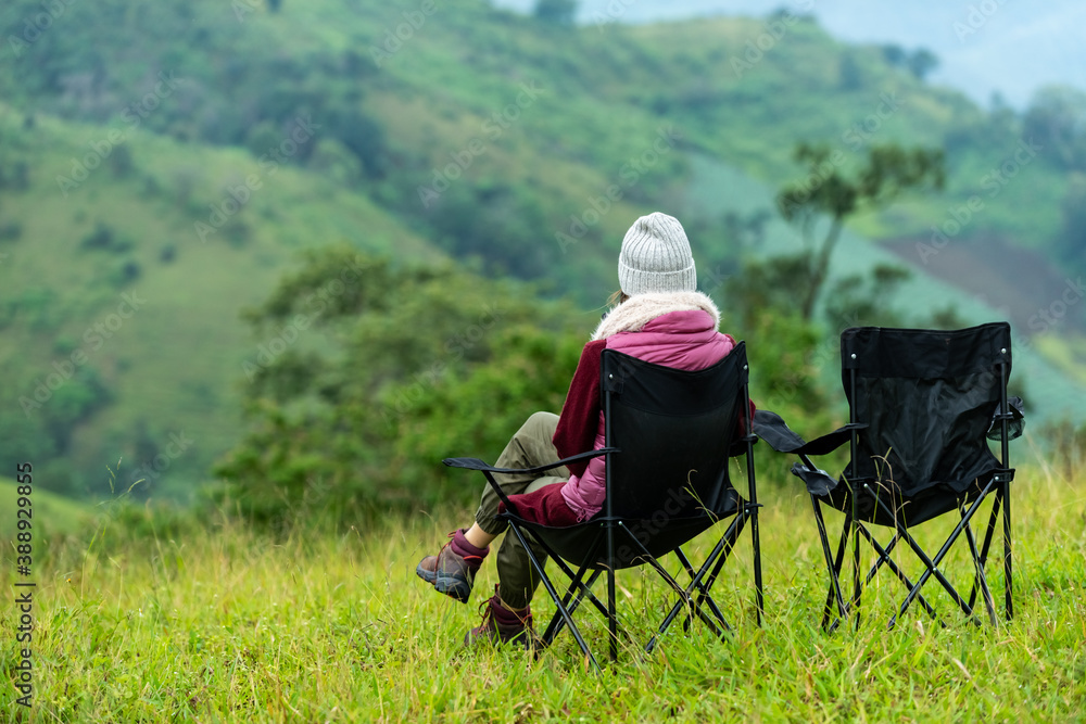 Happy young Asian woman hiker sitting on outdoor chair relaxing in beautiful nature of the mountain grass field in autumn. Loneliness pretty girl enjoy with outdoor lifestyle on holiday vacation. Happy young Asian woman hiker sitting on outdoor chair relaxing in beautiful nature of the mountain grass field in autumn. Loneliness pretty girl enjoy with outdoor lifestyle on holiday vacation.