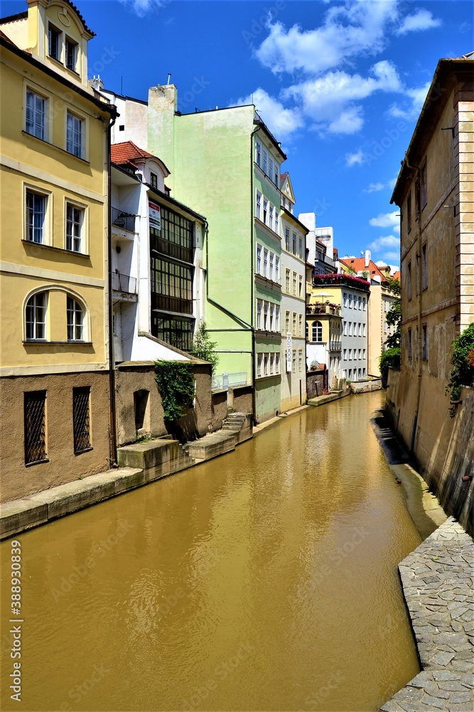 Ancient buildings and reflection in Vltava River. Prague and water street together with blue sky Czech Republic.