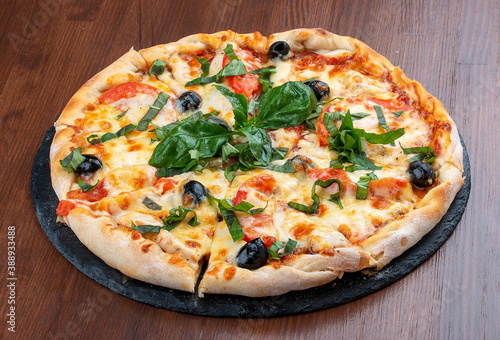 Pizza with salami and basturma, onions and basil