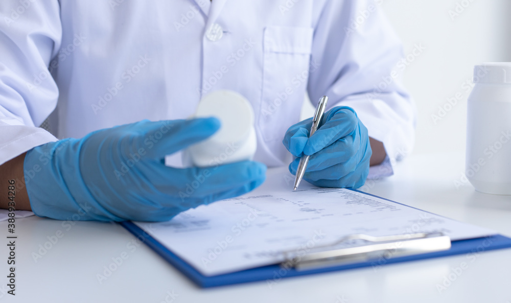 Closeup portrait, Scientists in white lab coats are analyzing the vital substance of the sample drug in a lab, Medical scientist for treatment concept. Closeup portrait, Scientists in white lab coats are analyzing the vital substance of the sample drug in a lab, Medical scientist for treatment concept.