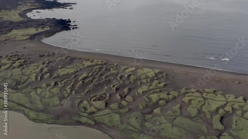 Aerial of distinctive black volcanic Sandvik beach on rugged shores of Iceland photo