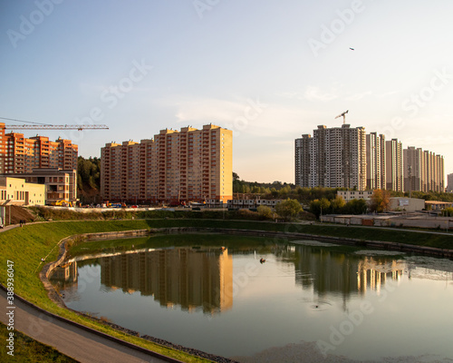 city ​​pond near high-rise buildings construction
