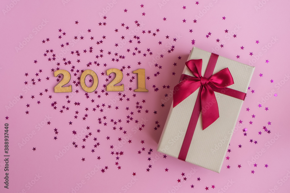 Gift box, pink stars sparkles and golden numbers 2021 on pink pastel background. Christmas, New Year, greetings concept. Copy space, flat lay, top view. Gift box, pink stars sparkles and golden numbers 2021 on pink pastel background. Christmas, New Year, greetings concept. Copy space, flat lay, top view.