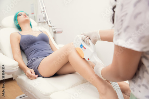 Young woman getting leg laser hair removal epilation. IPL treatment in cosmetic beauty salon