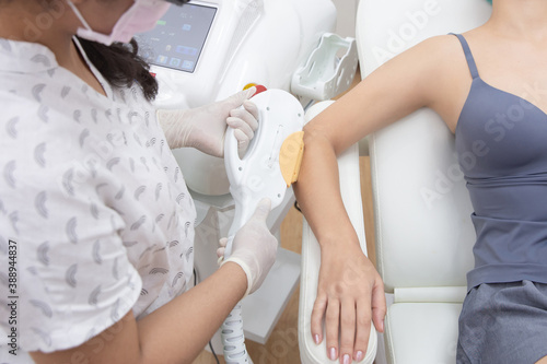 Young woman getting arm laser hair removal epilation. IPL treatment in cosmetic beauty salon