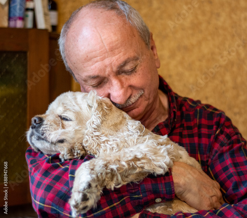 Obraz na płótnie Senior man hugging american cocker spaniel