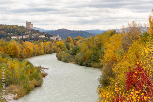 Donjon of the city of Crest with the Drôme river in foreground and autumn colors