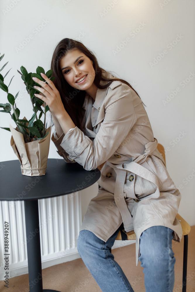 beautiful young woman sitting at a table and smiling beautiful young woman sitting at a table and smiling