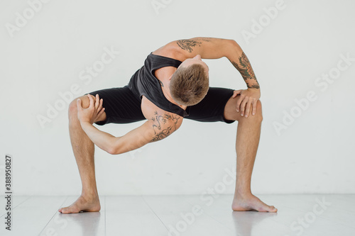 Twisting awkward yoga pose. Man twisted into yoga pose.