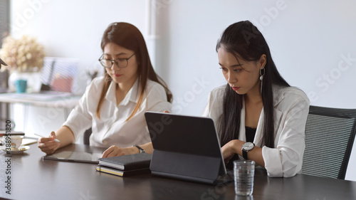 Two female businesspeople working together in meeting room