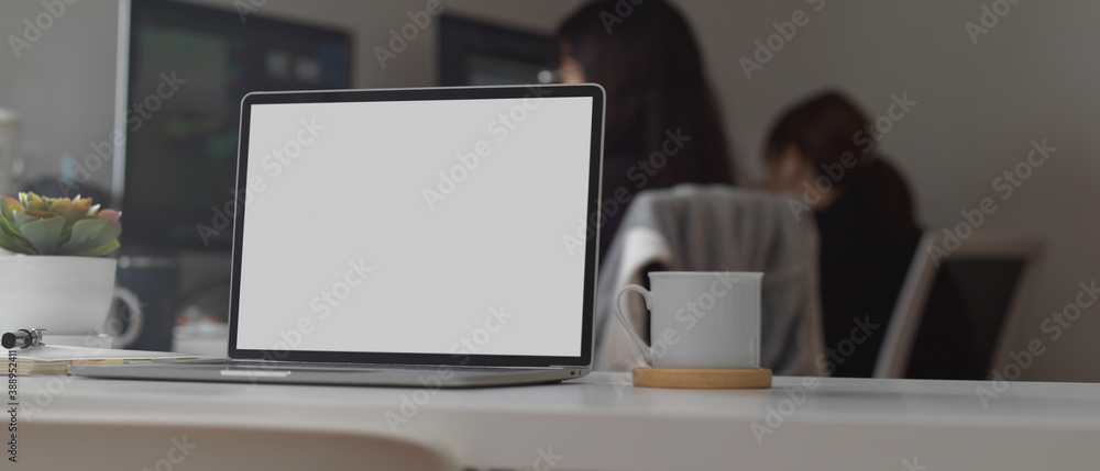 Worktable with laptop, coffee mug and copy space in office room, clipping path Worktable with laptop, coffee mug and copy space in office room, clipping path