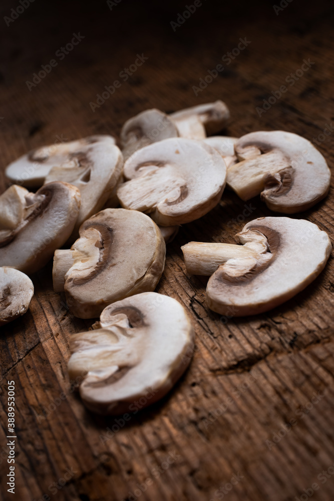 slices of champignon mushrooms over a wooden background. sliced mushrooms. mushrooms close up slices of champignon mushrooms over a wooden background. sliced mushrooms. mushrooms close up