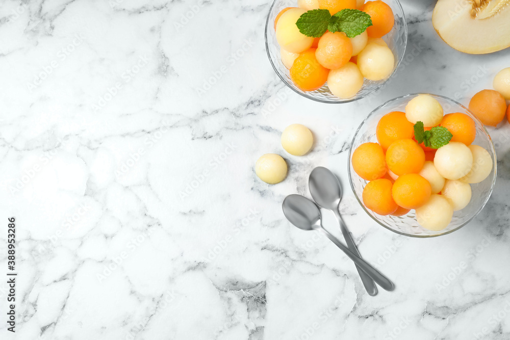 Flat lay composition with melon balls and mint on white marble table, space for text Flat lay composition with melon balls and mint on white marble table, space for text