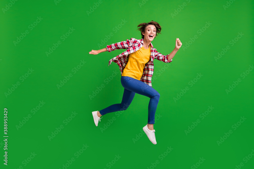 Full size profile photo of nice sweet girl jumping run hands fists wear trousers shirt sneakers isolated on green color background Full size profile photo of nice sweet girl jumping run hands fists wear trousers shirt sneakers isolated on green color background