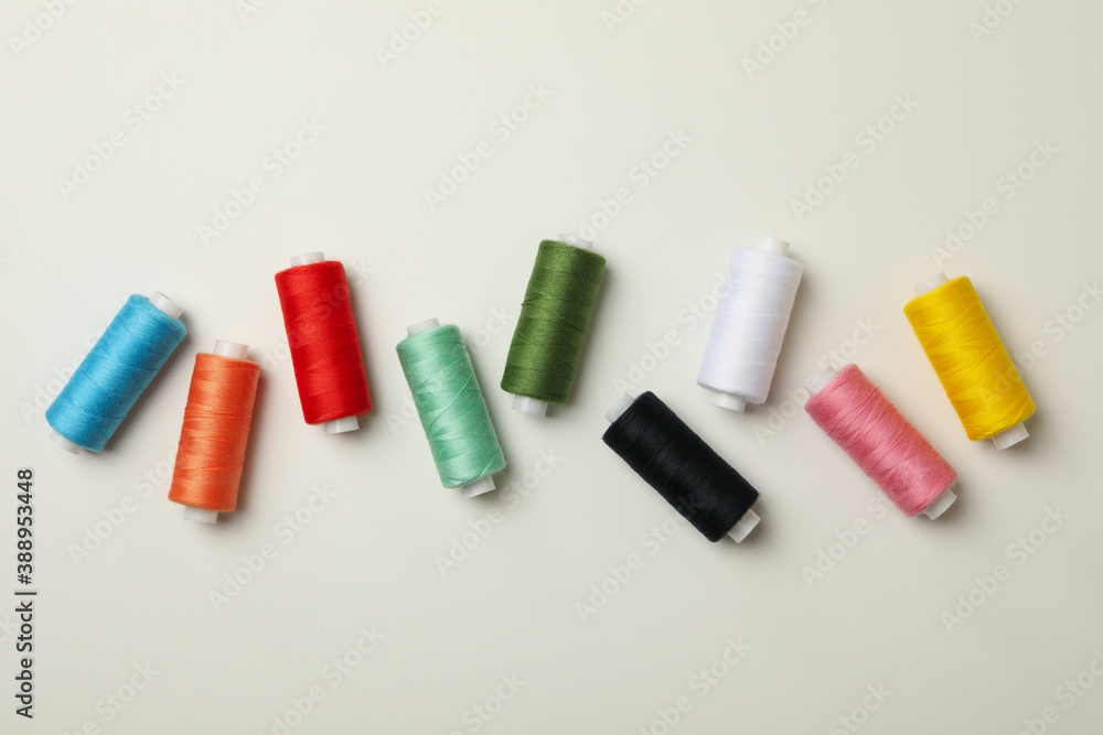 Color sewing threads on white background, top view Color sewing threads on white background, top view