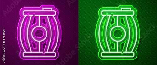 Glowing neon line Gun powder barrel icon isolated on purple and green background. TNT dynamite wooden old barrel. Vector.