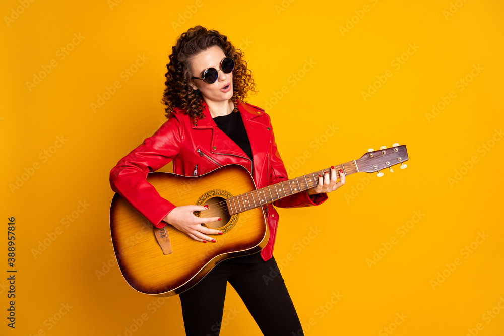 Portrait of attractive talented popular wavy-haired girl playing bass guitar isolated bright yellow color background Portrait of attractive talented popular wavy-haired girl playing bass guitar isolated bright yellow color background