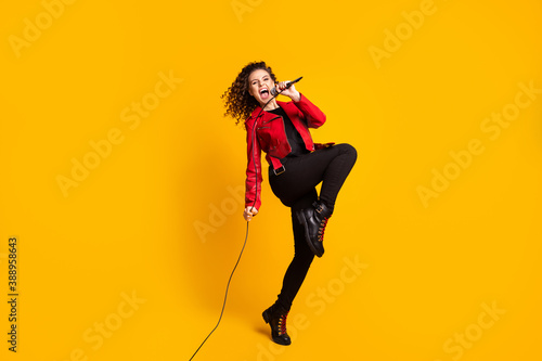 Full length body size view of nice wavy-haired girl vocalist star jumping singing hit having fun isolated on bright yellow color background