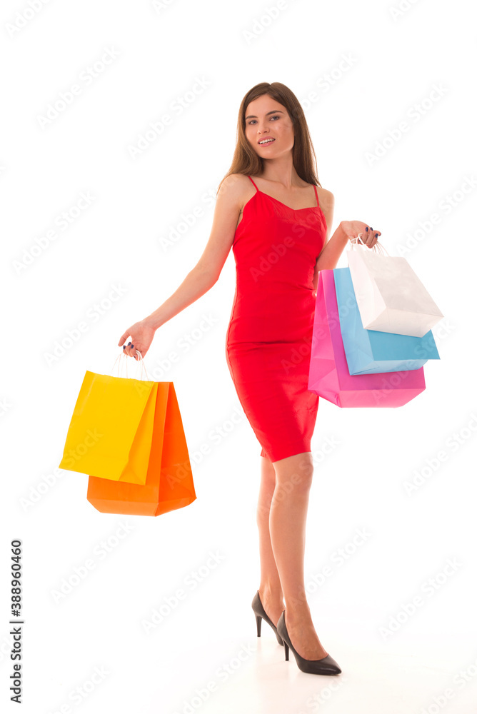Young girl posing for camera with new purchases after black friday. Girl in a red dress after a successful shopping Young girl posing for camera with new purchases after black friday. Girl in a red dress after a successful shopping