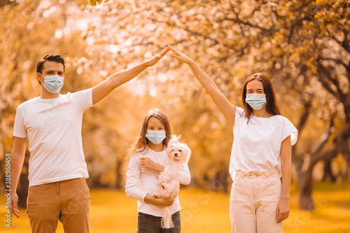 Adorable family in mwdical masks at autumn