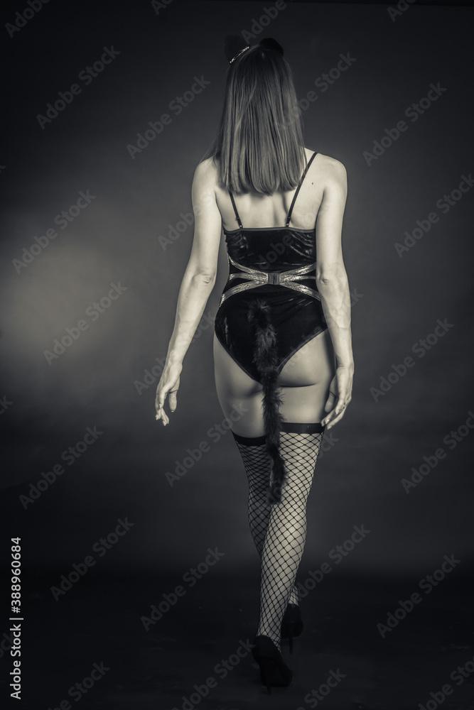 black and white photo in the Studio of a girl in a bodysuit and stockings.