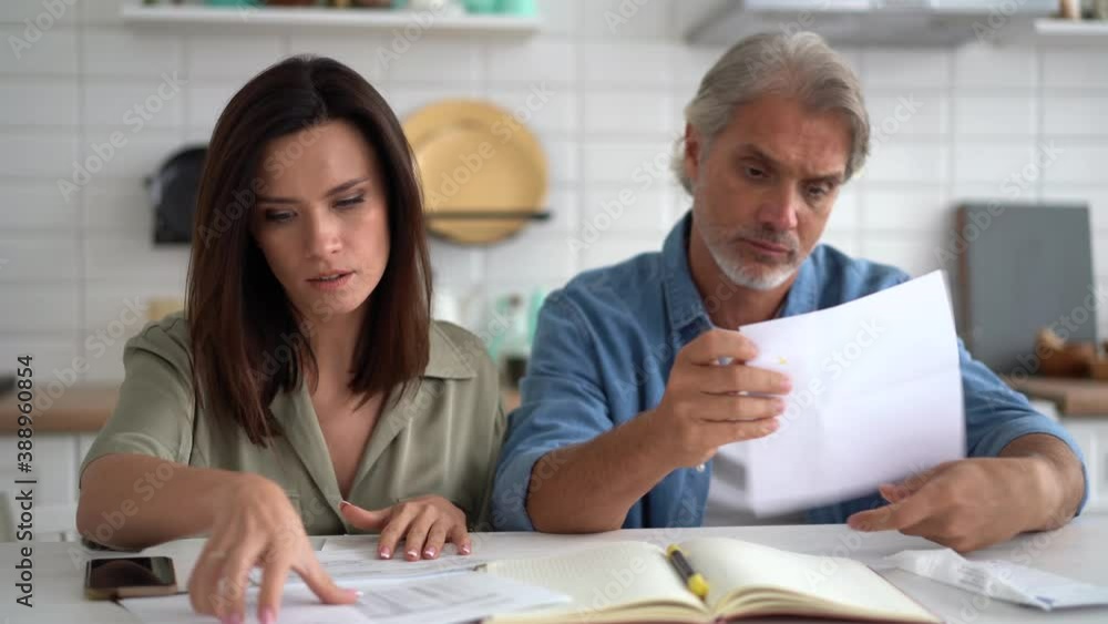 Family couple husband and wife doing paperwork planning budget expenses discussing money finances payments calculating paying bills together sit at kitchen table at home Family couple husband and wife doing paperwork planning budget expenses discussing money finances payments calculating paying bills together sit at kitchen table at home