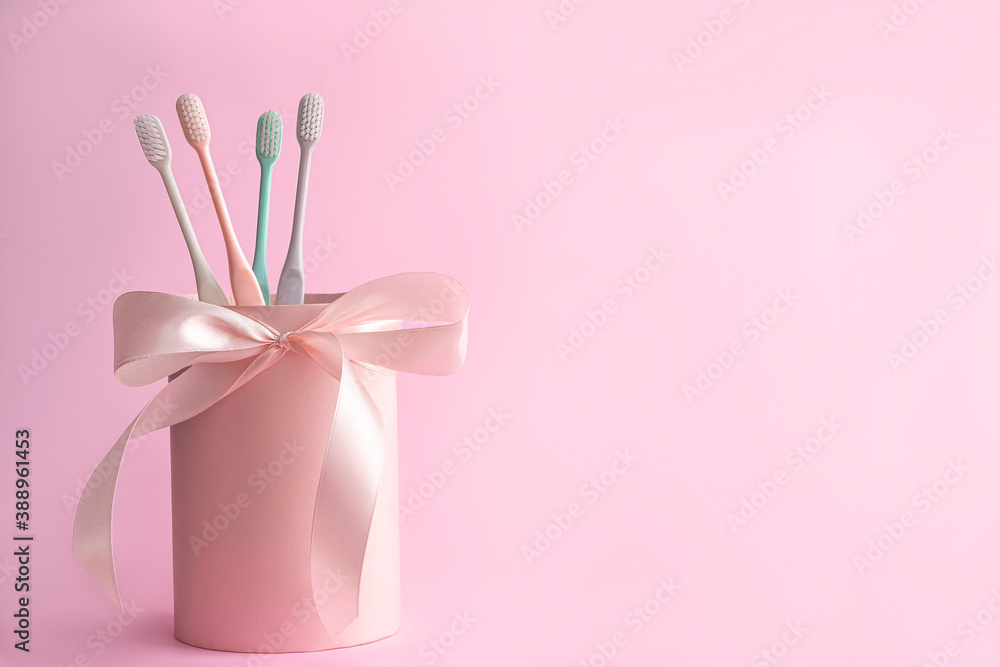 Pink packaging gift box with toothbrushes on pink background . Pink packaging gift box with toothbrushes on pink background .