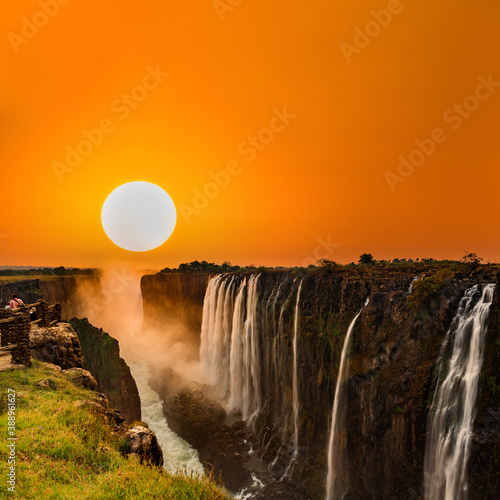 Supersized sun over Victoria Falls in Zambia with orange sky