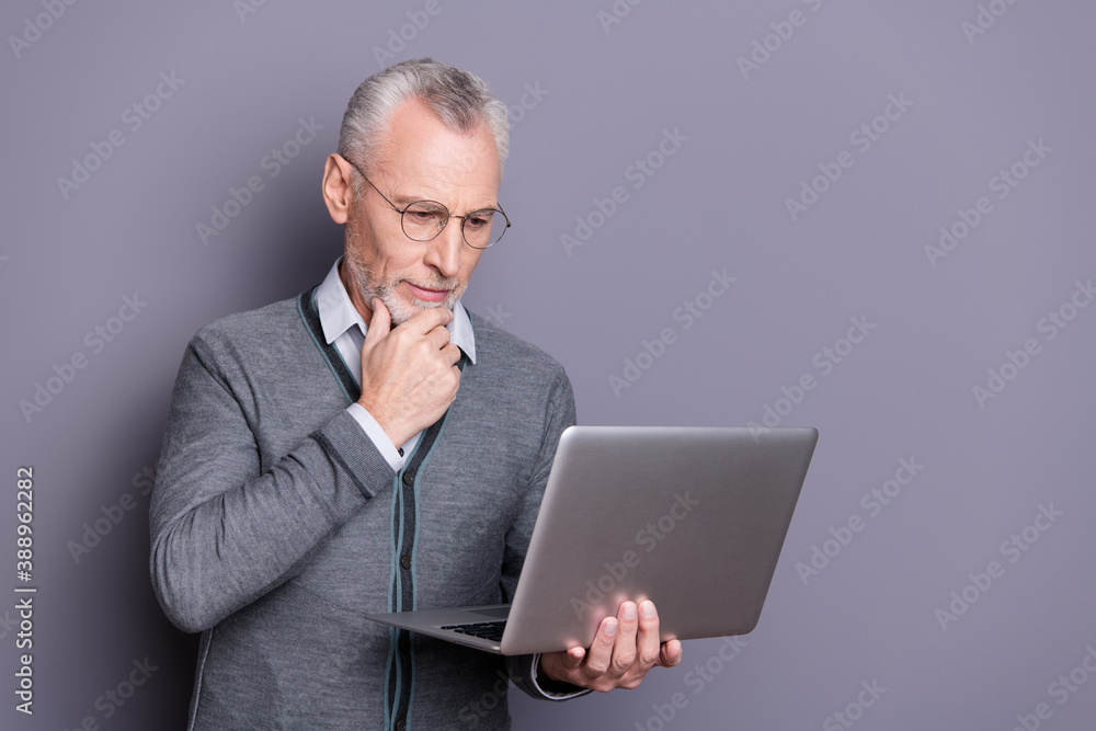 Portrait of his he nice attractive calm focused business shark wearing casual formal-wear using netbook reading browsing e-commerce isolated over gray pastel background Portrait of his he nice attractive calm focused business shark wearing casual formal-wear using netbook reading browsing e-commerce isolated over gray pastel background