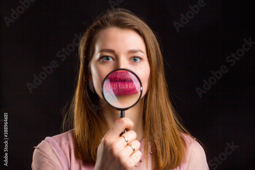 With long blonde hair, enhances the lips with the lipstick with a magnifying glass.