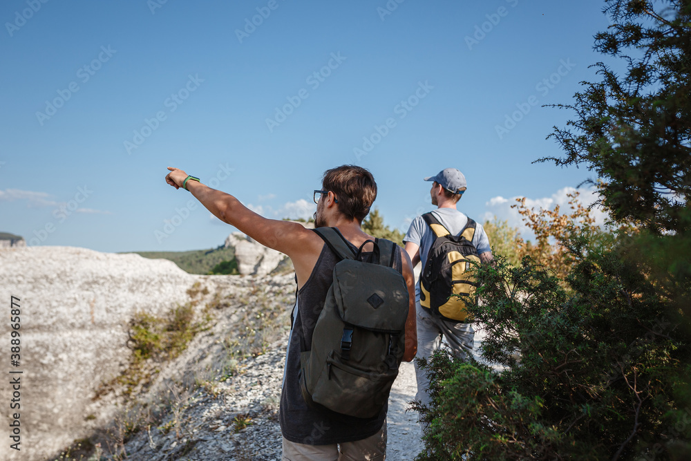 Two Hikers with Backpacks and other climbing Gear staying on top
