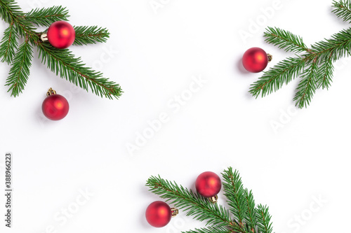 Minimal christmas composition. Fir tree branches with red christmas balls on white background. Top view. Copy space