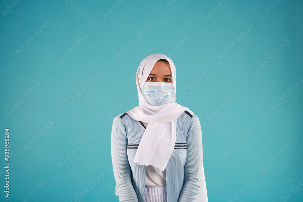 Young beautiful Asian woman wear protective face mask in prevention against Coronavirus epidemic isolated on blue background. Young beautiful Asian woman wear protective face mask in prevention against Coronavirus epidemic isolated on blue background.