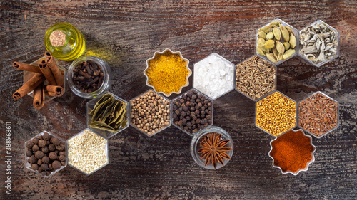 Fototapeta Naklejka Na Ścianę i Meble -  Spices in hexagonal jars on a wooden surface