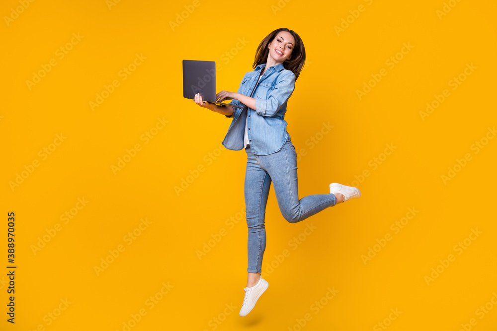 Full length body size view of her she nice slim fit cheerful successful learner jumping walking using laptop watch video tutorial university isolated bright vivid shine vibrant yellow color background Full length body size view of her she nice slim fit cheerful successful learner jumping walking using laptop watch video tutorial university isolated bright vivid shine vibrant yellow color background