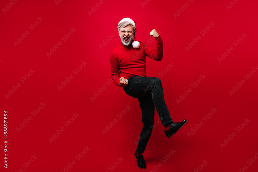 Joyful old man expressing happiness in christmas. Studio photo of positive santa claus dancing with smile. Joyful old man expressing happiness in christmas. Studio photo of positive santa claus dancing with smile.