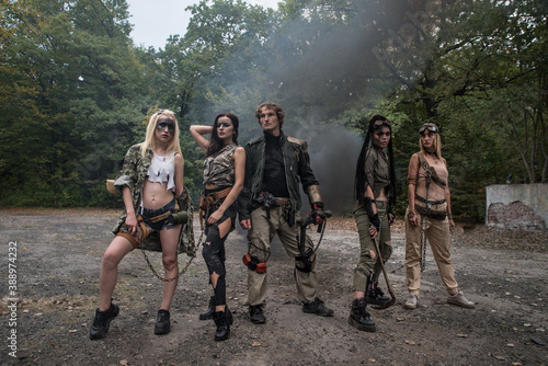 A group of young people in tattered clothes after the apocalypse. Smoke, grunge, chains, aggressive combat makeup