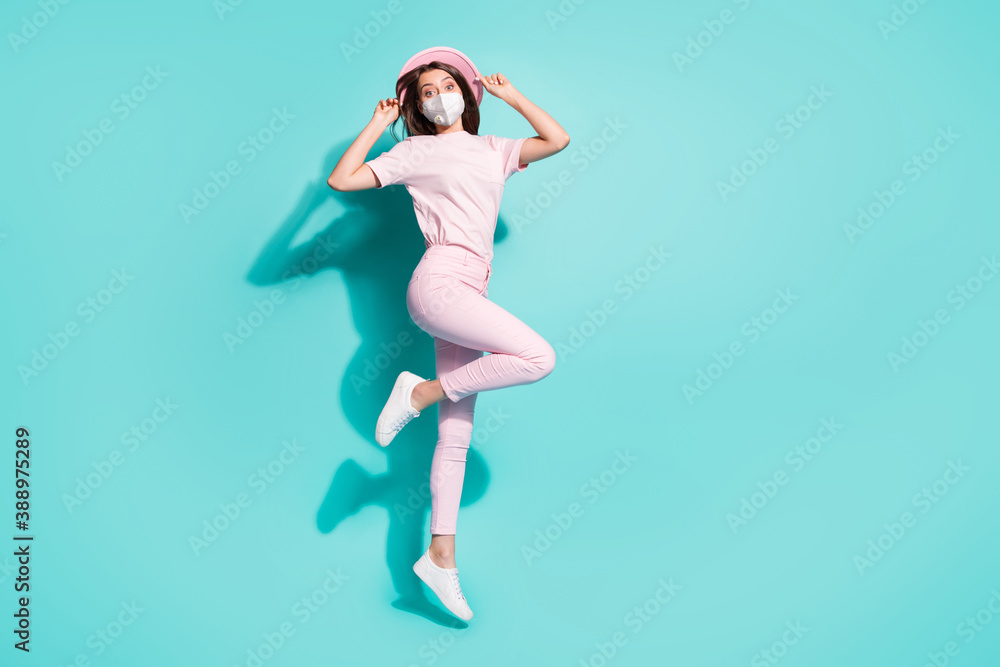 Full length photo of girl jumping having fun wear protective safety facial mask isolated turquoise color background