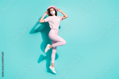 Fototapeta Naklejka Na Ścianę i Meble -  Full length photo of girl jumping having fun wear protective safety facial mask isolated turquoise color background
